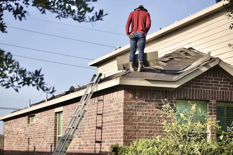 Professional roofer working on a residential roof in Spruce
